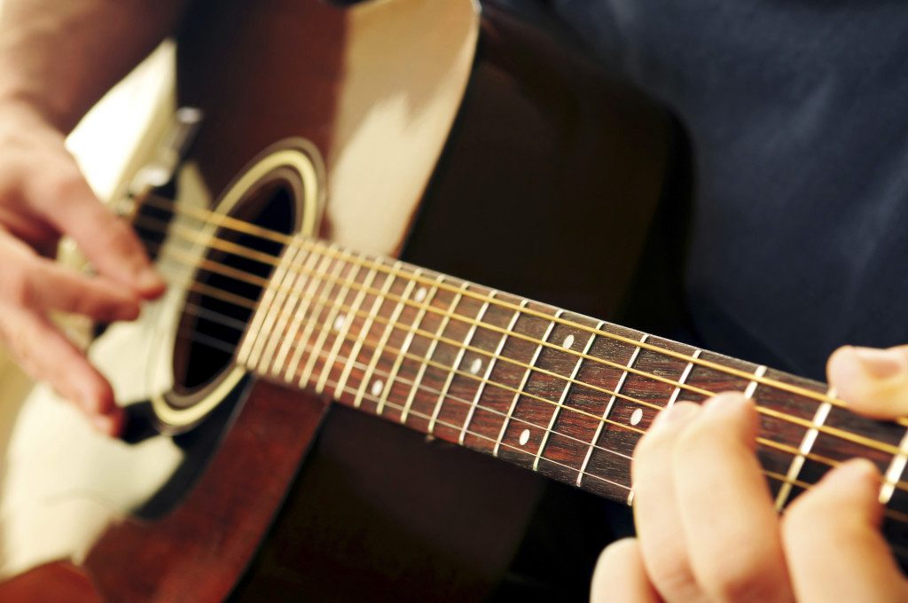 Hands of a person playing an acoustic guitar